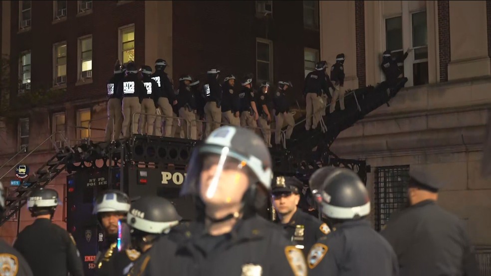 Polícia usa escada para acessar janela em Columbia. — Foto: GloboNews/Reprodução