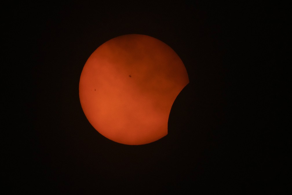 Nuvens passam enquanto a fase inicial de um eclipse solar total é visível no Texas — Foto: Julio Cortez/AP Photo