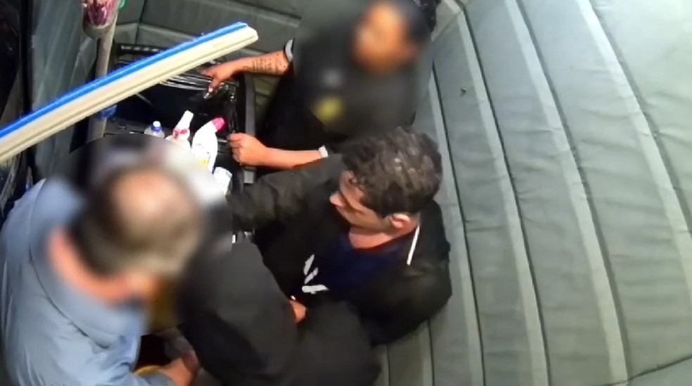 Reféns dentro de elevador com dois suspeitos (vestidos de preto) — Foto: Reprodução