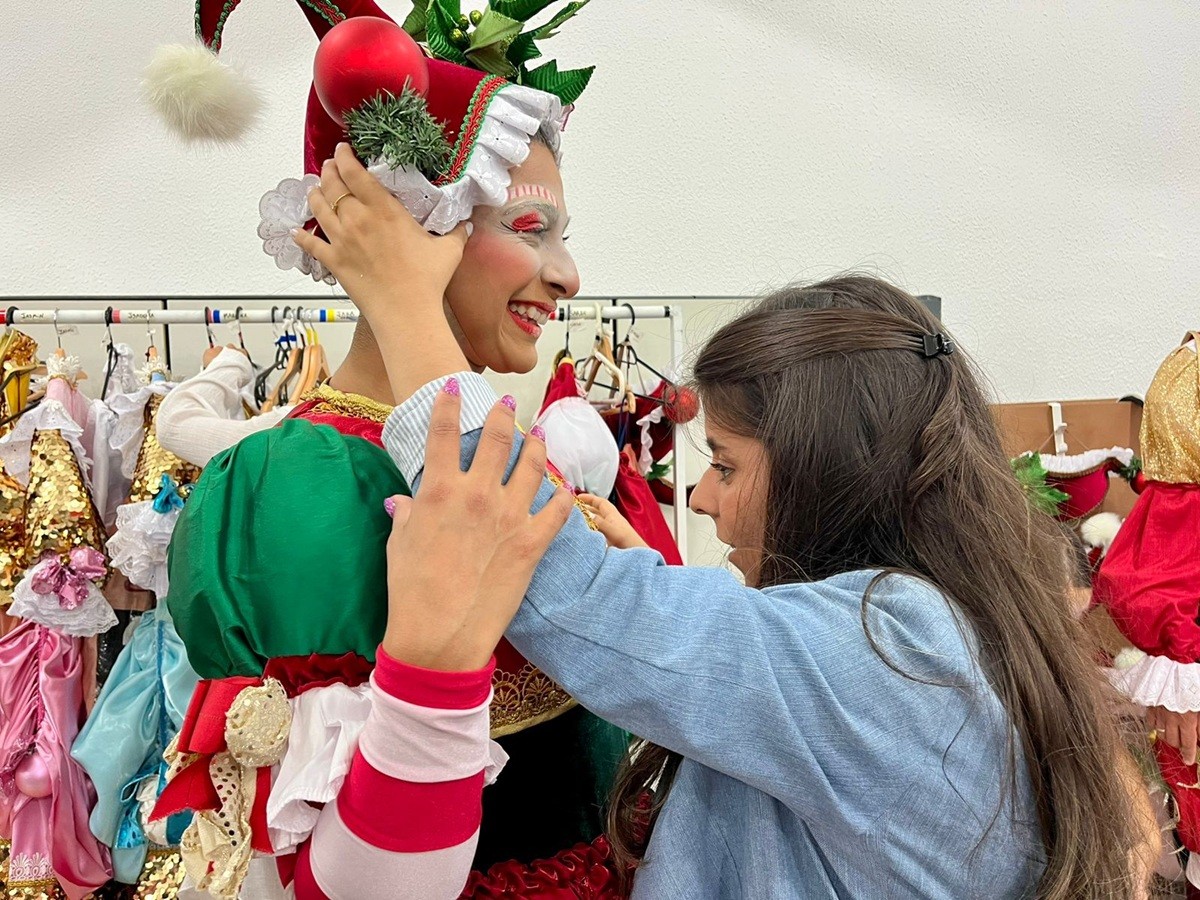 Jovem com deficiência visual realiza sonho de conhecer personagens e carros do desfile de Natal em Balneário Camboriú