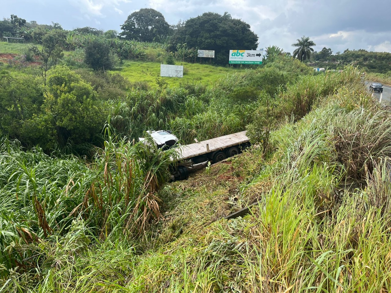 Carreta com 20 toneladas de cal tomba e cai em ribanceira de 6 metros na BR-354, em Formiga