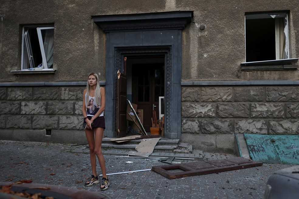 Mulher em frente a um edifício residencial atingido durante um ataque de drones e mísseis russos, no meio do ataque da Rússia à Ucrânia, em Lviv, na Ucrânia — Foto: Reuters/Roman Baluk