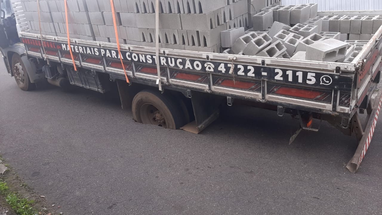 Caminhão fica preso em buraco em rua de Mogi das Cruzes