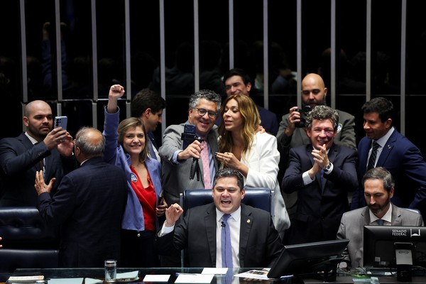 Colegas parlamentares comemoram enquanto o presidente do Senado Federal, Davi Alcolumbre, anuncia o resultado da votação a favor de uma emenda constitucional que reduz a jornada de trabalho no Brasil de seis para cinco dias, em Brasília, Brasil, 14 de outubro de 2026 — Foto: REUTERS/Adriano Machado