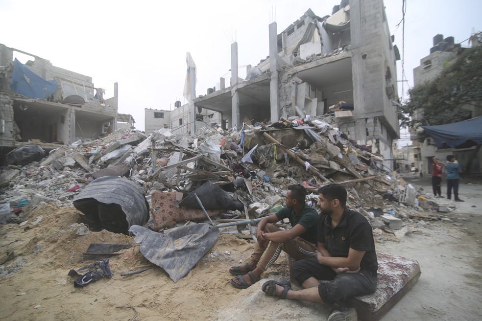 Palestinos em meio a destruição na Faixa de Gaza — Foto: AP Photo/Hatem Ali