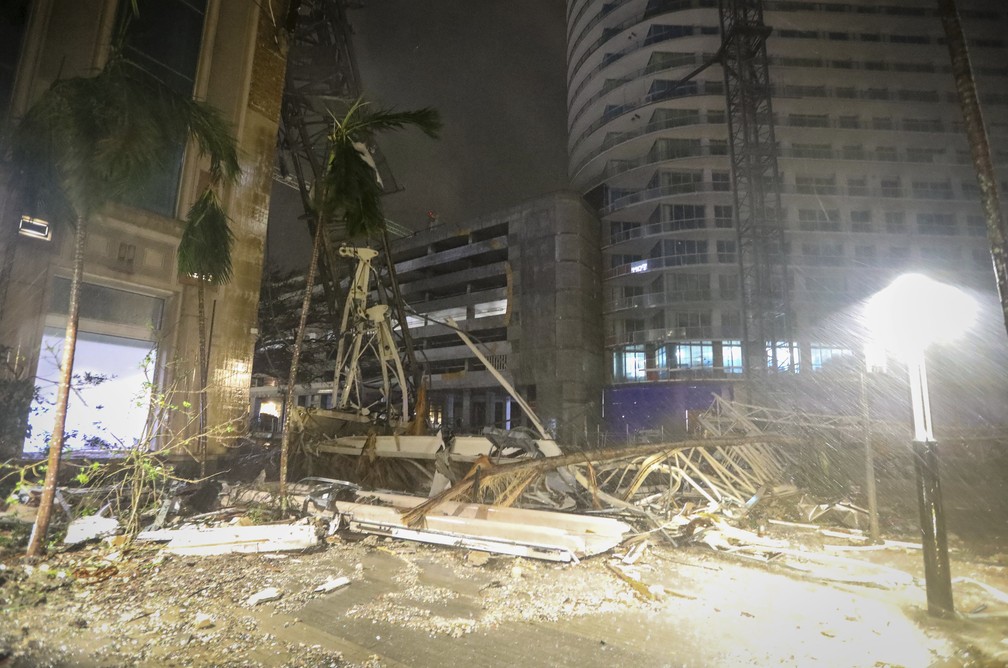Destroços cobrem o chão próximo a um guindaste que caiu sobre um edifício em São Petersburgo, na Flórida, com os fortes ventos do furacão Milton — Foto: Chris Urso/Tampa Bay Times via AP