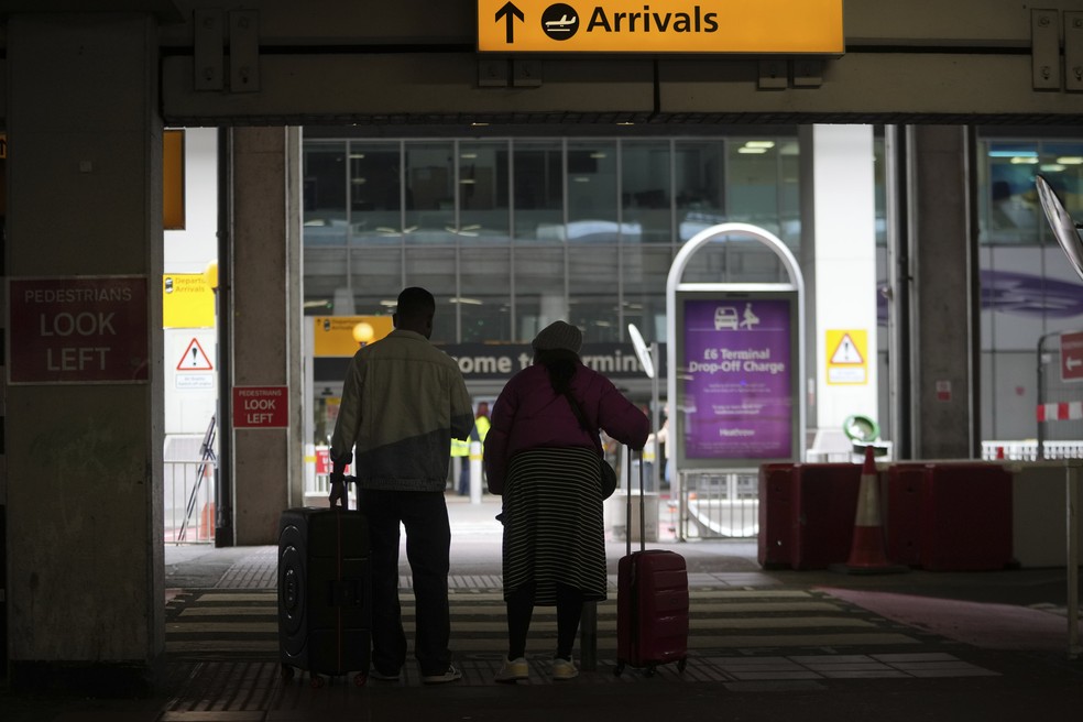 Viajantes chegam ao aeroporto de Heathrow apesar do fechamento após incêndio — Foto: AP Photo/Kin Cheung