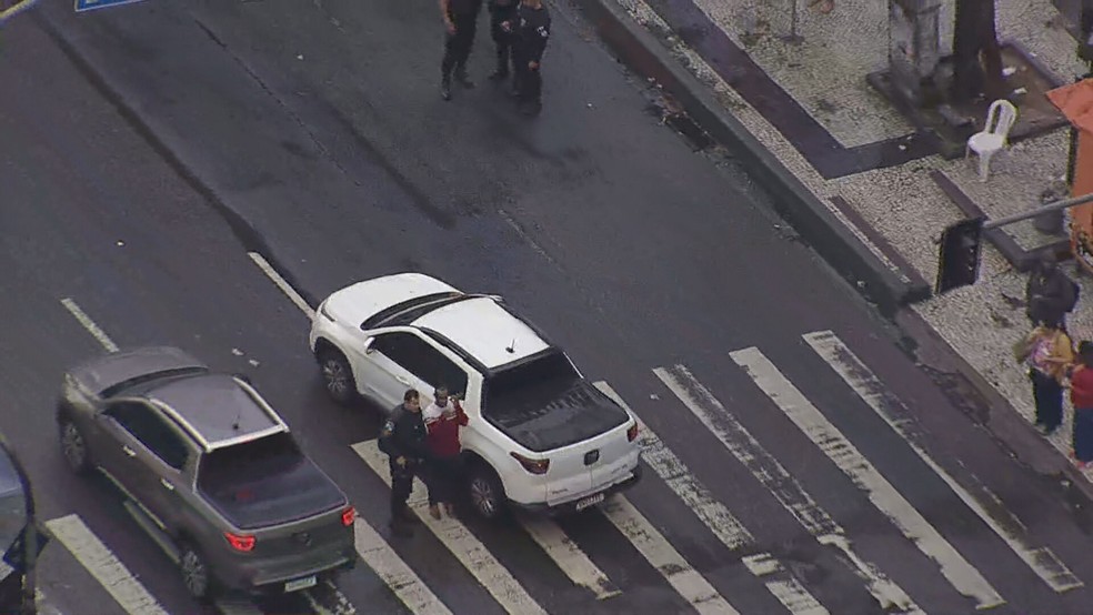 Motorista do carro conversa com um policial militar após o acidente — Foto: Reprodução/TV Globo