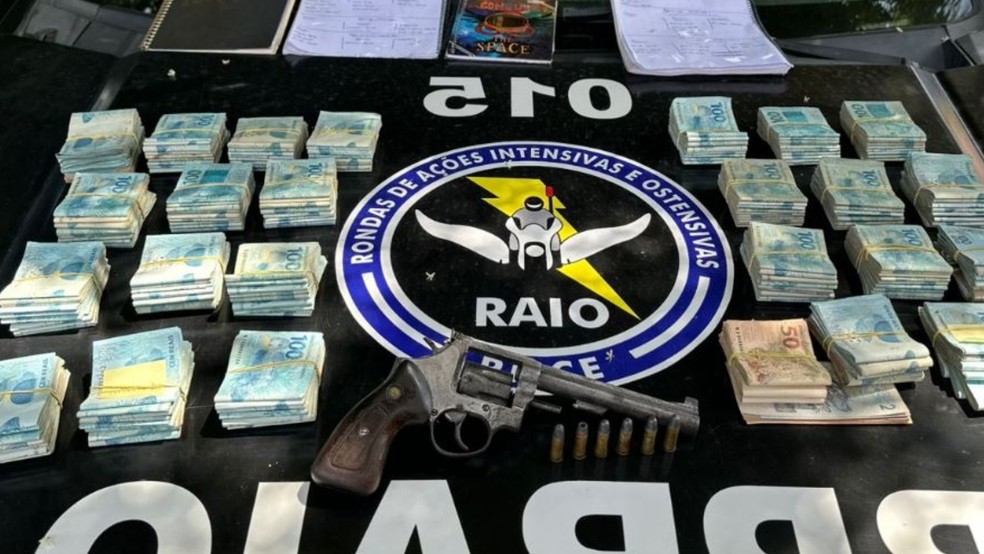 Polícia apreende arma municiada e mais de R$ 200 mil em espécie durante prisão de agiota em Quixeramobim. — Foto: PMCE/ Divulgação