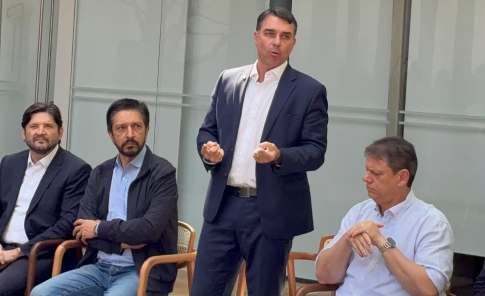 Flávio Bolsonaro (de pé), entre André do Prado (esq), Ricardo Nunes e Tarcísio de Freitas (dir), em encontro em São Paulo, em 31 de julho — Foto: Divulgação