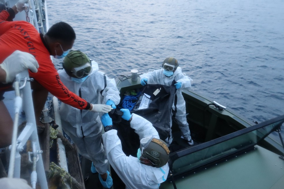 Equipes de resgate transferem os restos mortais das vítimas do recente incêndio na balsa MV June Aster — Foto: PHILIPPINE COAST GUARD via AP
