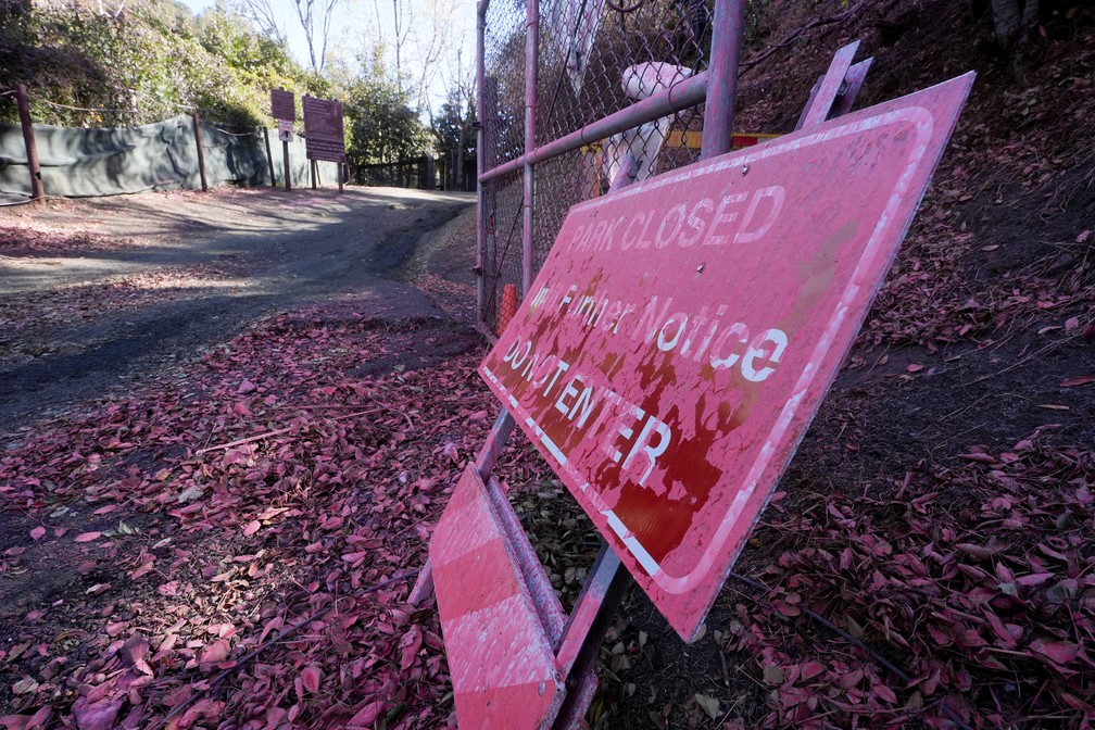 Retardante rosa de fogo cobre uma placa em área atingida por incêndio em Mandeville Canyon, Los Angeles — Foto: Richard Vogel/AP