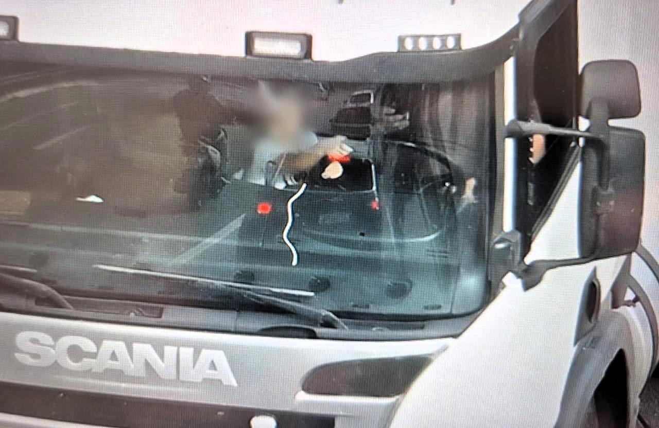 Foto flagra criança segurando volante de caminhão enquanto motorista usa celular em SC