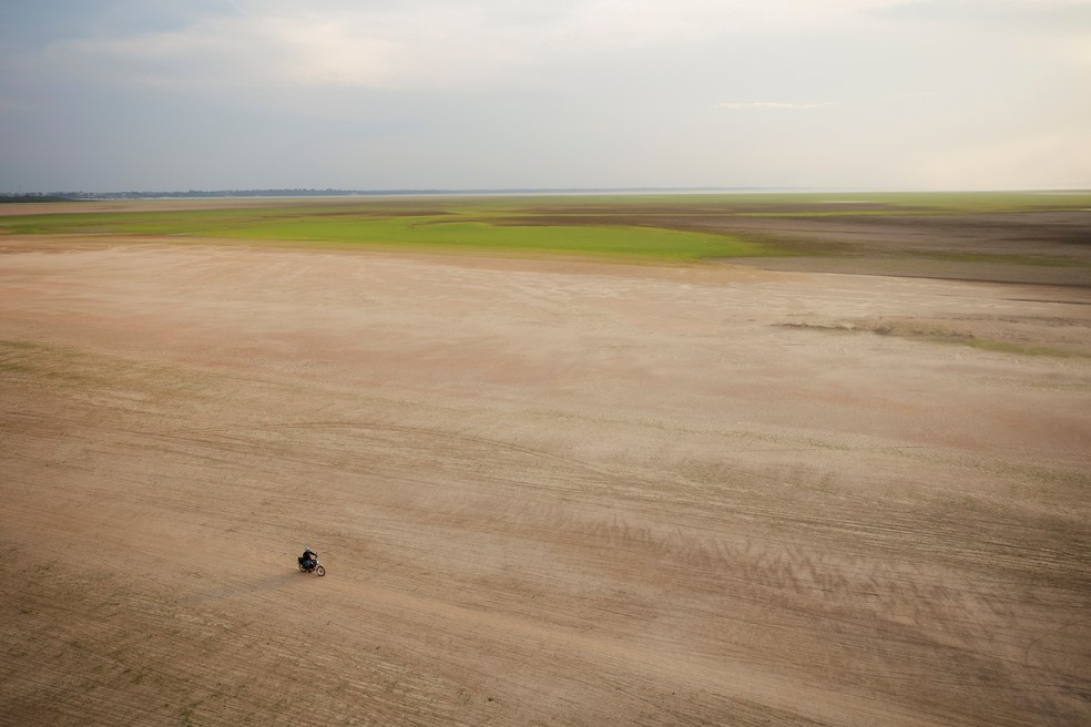 Vista aérea mostra homem de moto no Lago Tefé, afetado pela seca do rio Solimões, durante voo de monitoramento do ICMBio em 4 de outubro de 2023. — Foto: REUTERS/Bruno Kelly