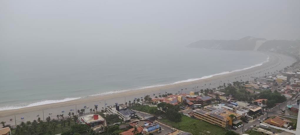 Chuva alaga faixa de areia na engorda da praia de Ponta Negra em Natal