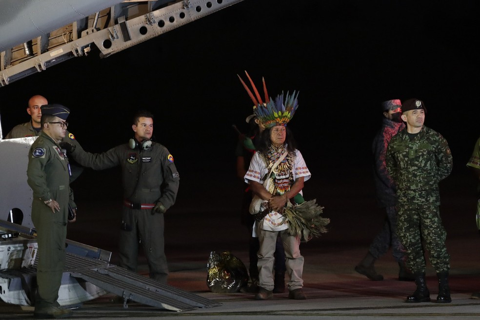 Militares e um líder indígena que viajaram com as crianças para uma base militar em Bogotá, após a chegada do avião que levou o grupo para a capital colombiana, em 10 de junho de 2023.  — Foto: Ivan Valencia/ AP 
