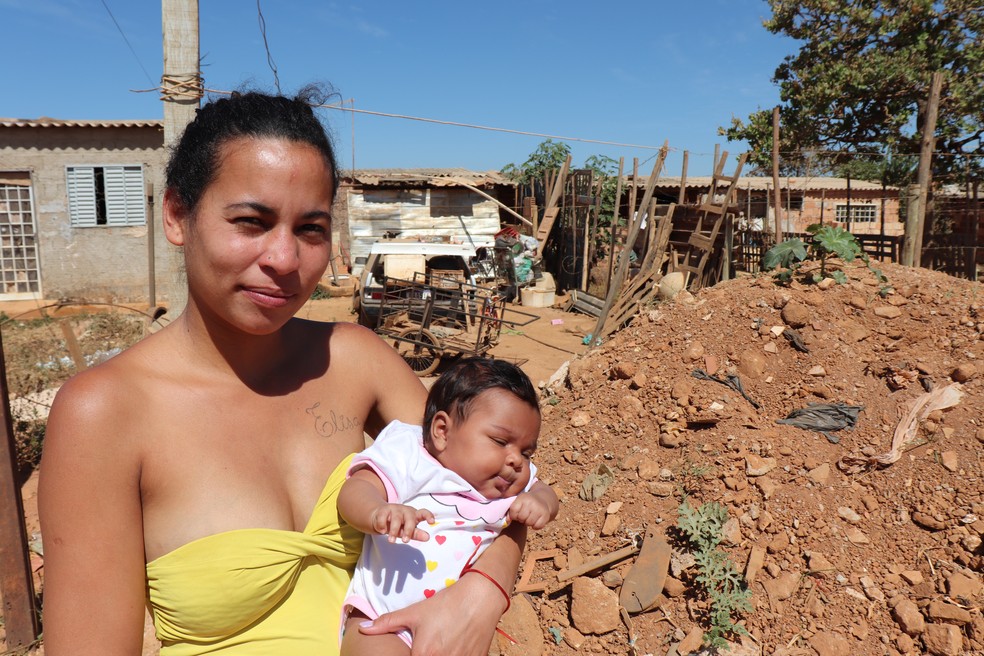 Bruna Nascimento dos Santos e a filha Aylla em frente  casa onde moram no trecho 3 do Sol Nascente. — Foto: Fernanda Bastos/g1 DF