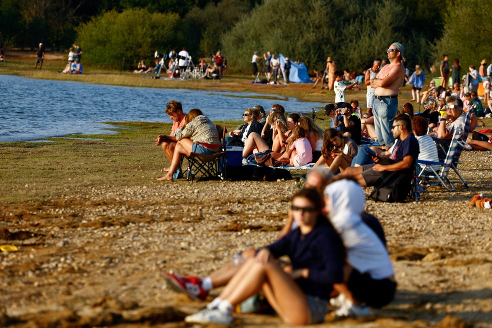 Pessoas usam óculos de proteção para observar o eclipse solar antes da fase de totalidade, em Arija, na Espanha, nesta quarta-feira (12). — Foto: Borja Suarez/Reuters
