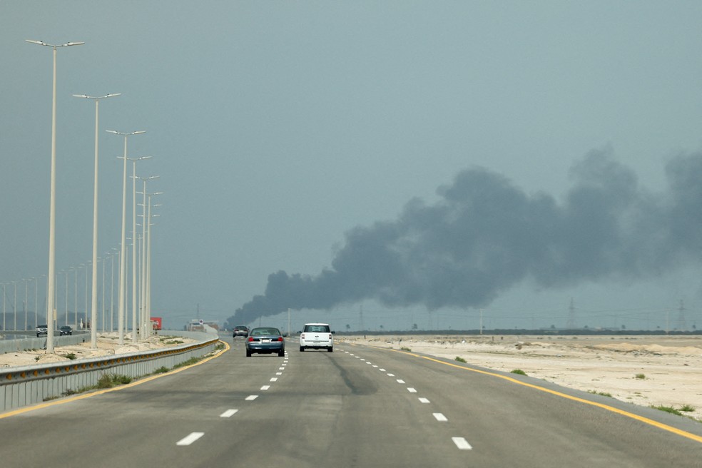 Veículos trafegam por uma estrada enquanto fumaça sobe da refinaria de petróleo Ras Tanura da Saudi Aramco, após um suposto ataque de drone iraniano, em Ras Tanura, Arábia Saudita. — Foto: REUTERS/Stringer
