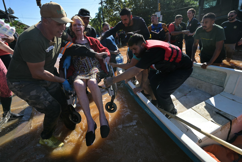 6 de maio - Idosa em cadeira de rodas é erguida resgatada em área alagada de Porto Alegre — Foto: Nelson Almeida/AFP