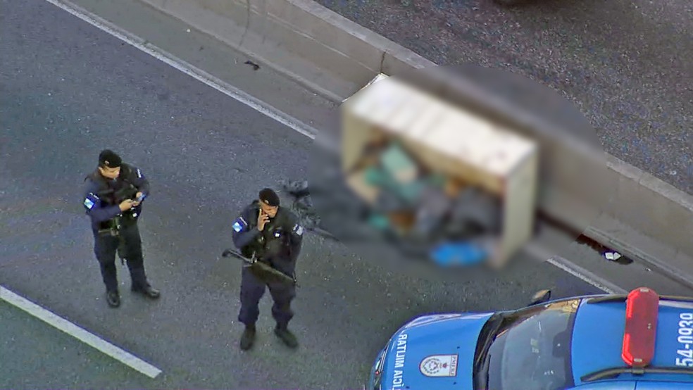 PMs isolam área onde corpo foi encontrado — Foto: Reprodução/TV Globo