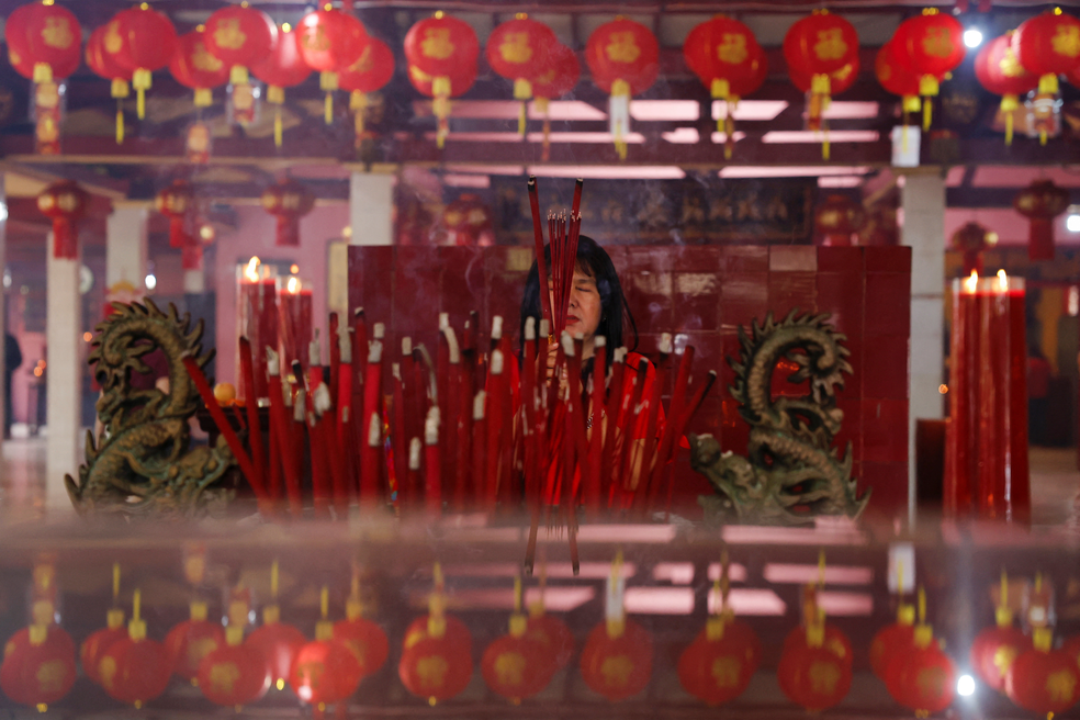 Mulher reza diante de velas nas celebrações do Ano Novo Chinês, em 28 de janeiro de 2025. — Foto: Ajeng Dinar Ulfiana/ Reuters