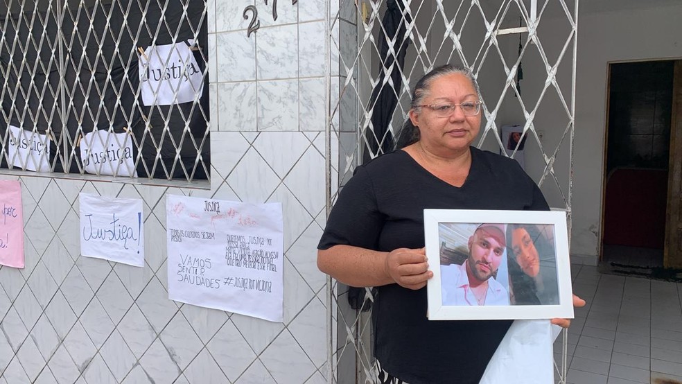 Em velório, avó paterna de Victória segurando foto da menina e do pai, que morreu no ano passado — Foto: Amy Nascimento