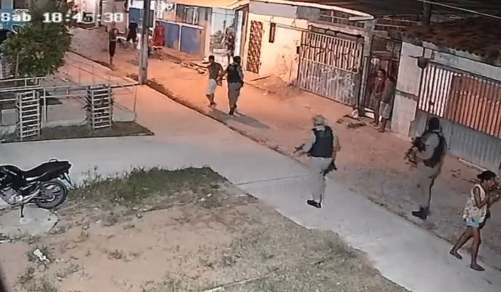 Imagem mostra policiais com suspeito detido na comunidade — Foto: Divulgação