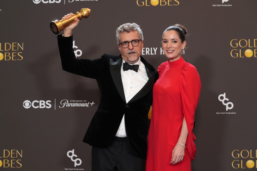 Kleber Mendon�a Filho e Emilie Lesclaux mostram Globo de Ouro por melhor filme em l�ngua n�o-inglesa de 'O agente secreto' � Foto: Chris Pizzello/AP