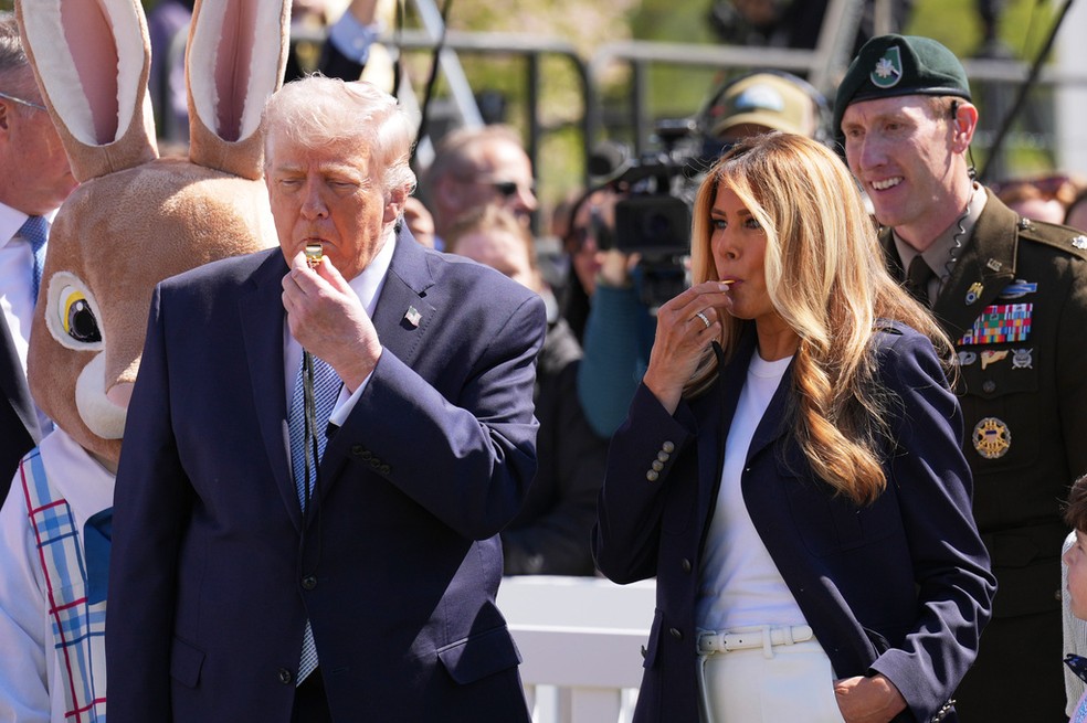 Presidente dos Estados Unidos, Donald Trump, ao lado da primeira-dama dos EUA, Melania Trump, comem chocolate durante evento de Páscoa na Casa Branca, em 6 de abril de 2026. — Foto: Mark Schiefelbein/ AP