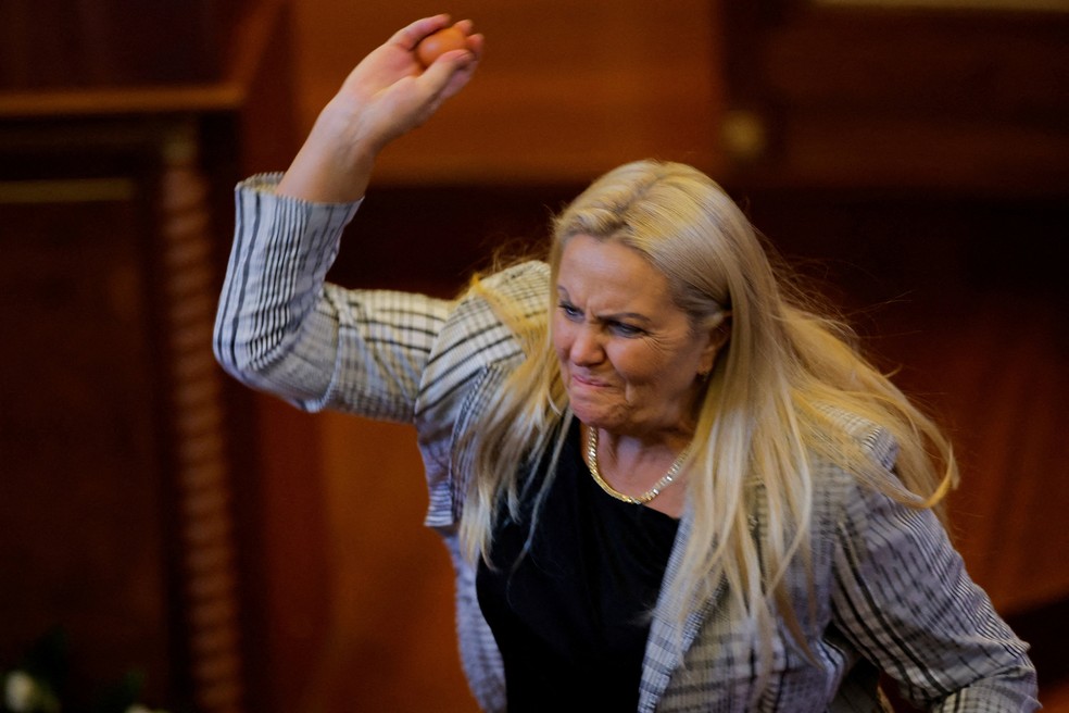 A parlamentar kosovar Time Kadriaj atira um ovo contra o primeiro-ministro interino Albin Kurti. — Foto: REUTERS/Valdrin Xhemaj