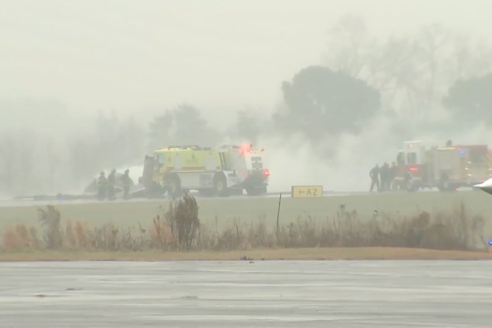 Equipes de emergência apagam incêndio após queda de avião no aeroporto regional de Statesville, na Carolina do Norte, nos Estados Unidos, em 18 de dezembro de 2025. — Foto: WSOC via AP