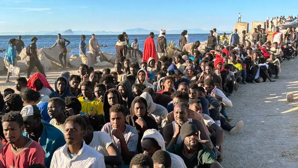 Centenas de migrantes foram fotografados em fila em uma praia em Ceuta para receber ajuda humanitária. — Foto: GETTY IMAGES via BBC