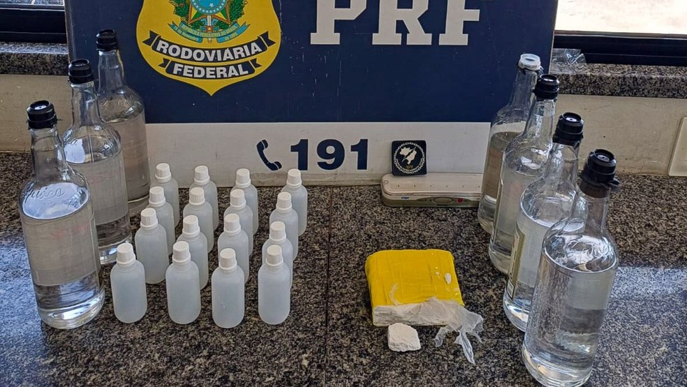 Policiais encontraram no porta-malas do automóvel uma caixa de papelão com sete garrafas de lança-perfume e meio tablete de cloridrato de cocaína. — Foto: PRF/ Divulgação