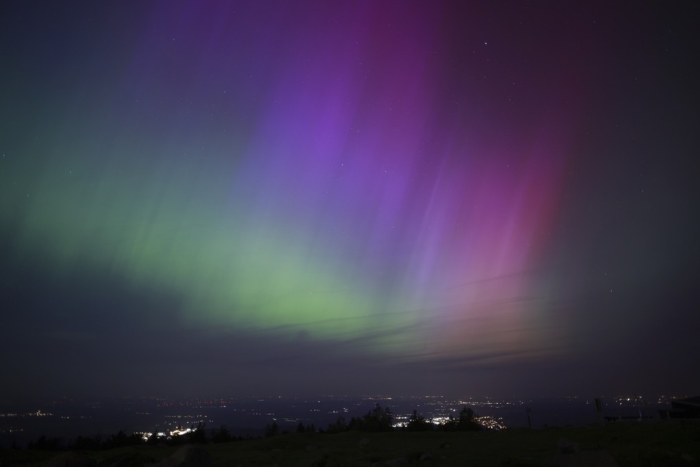 Luzes da aurora boreal so vistas sobre Brocken, perto de Schierke, na Alemanha.  — Foto: Matthias Beina/DPA via AP