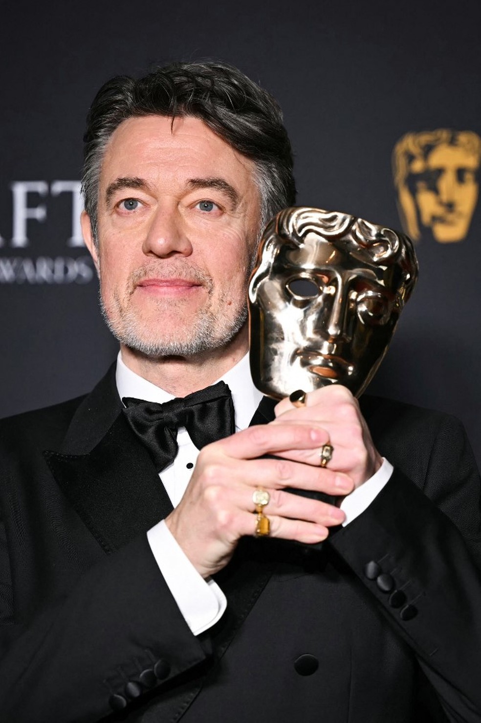 O roteirista inglês Peter Straughan, de "Conclave", com o BAFTA de Melhor Roteiro Adaptado — Foto: Justin Tallis/AFP