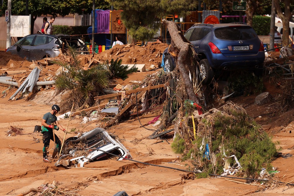 Bombeiro observa carro submerso na lama em Paiporta, bairro no sul de Valência, na Espanha, após enchente que matou mais de 150 pessoas, em 1º de novembro de 2024. — Foto: Nacho Doce/ Reuters