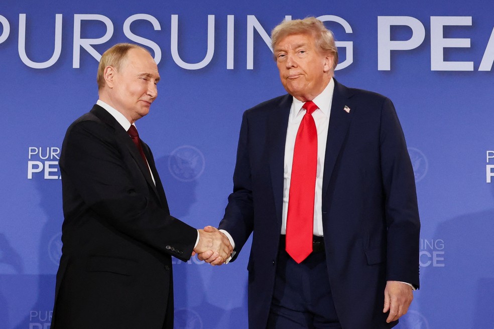 Putin e Trump se cumprimentam após discurso no Alasca — Foto: REUTERS/Kevin Lamarque
