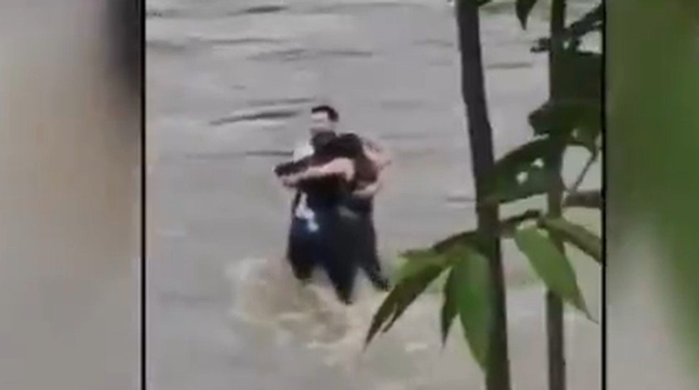 Amigos se abraçam antes de serem arrastados por enchente na Itália. — Foto: Reprodução/Globonews