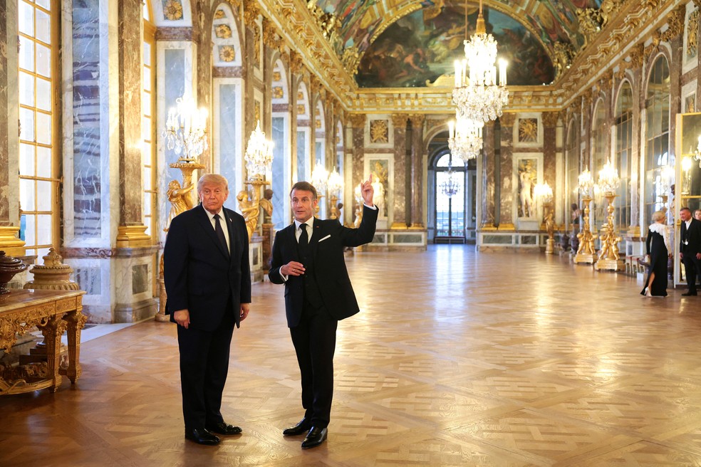 Emmanuel Macron e Donald Trump fazem tour na Sala dos Espelhos do Palácio de Versalhes, em 17 de junho de 2026 — Foto: Anna Moneymaker/Pool via Reuters
