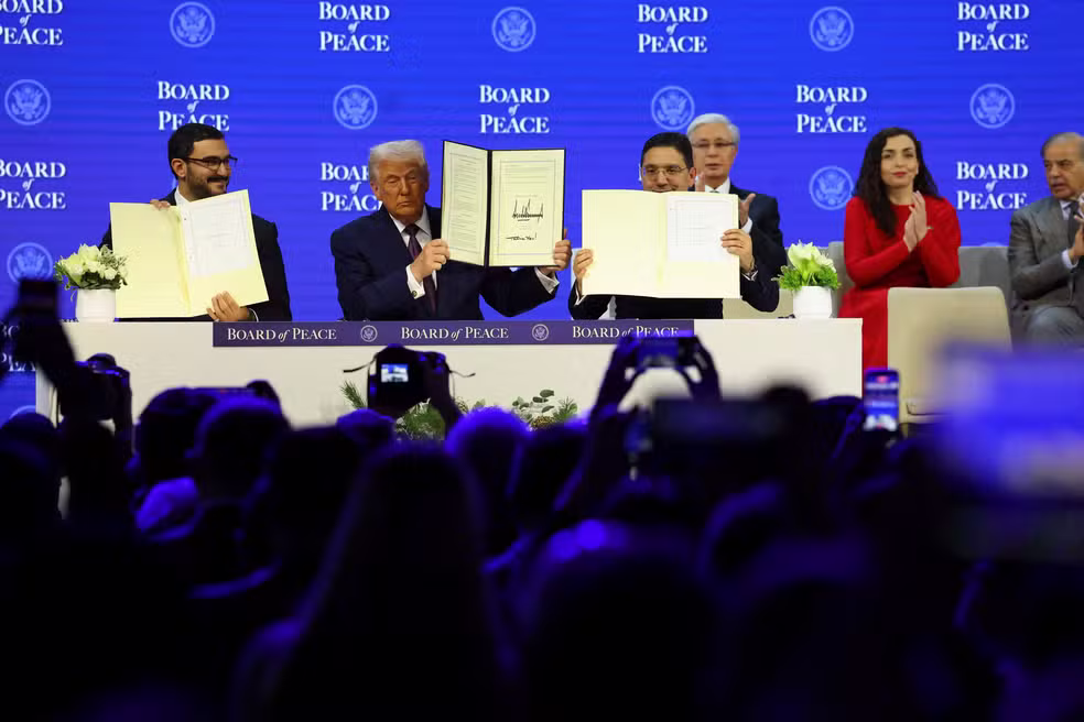 O Ministro da Corte do Primeiro-Ministro do Bahrein, Shaikh Isa bin Salman bin Hamad Al Khalifa, o Presidente dos EUA, Donald Trump, e o Ministro das Rela&ccedil;&otilde;es Exteriores de Marrocos, Nasser Bourita, seguram a Carta assinada do Conselho da Paz, que visa a resolu&ccedil;&atilde;o de conflitos globais. &mdash; Foto: Denis Balibouse/Reuters