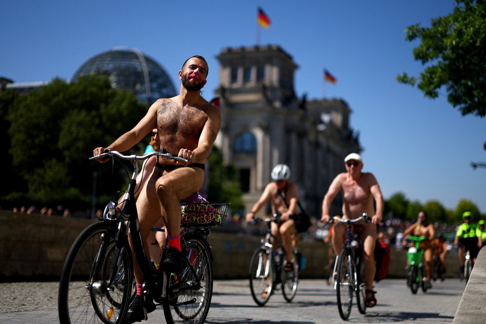Ciclistas nus passam em frente ao Parlamento Alemão durante o evento World Naked Bike Ride em Berlim — Foto: REUTERS/Lisi Niesner