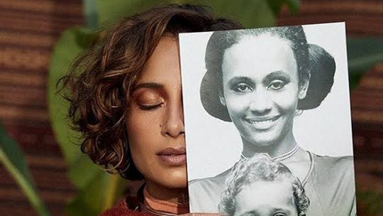 É #FAKE que foto antiga mostre Camila Pitanga loira no colo da mãe; imagem foi manipulada por inteligência artificial - Post viralizou ao mostrar versão adulterada de retrato da artista na infância. Conteúdo passou a circular dias após participação da artista em podcast apresentado por Mano Brown; episódio gerou debate nas redes sociais sobre identidade racial.