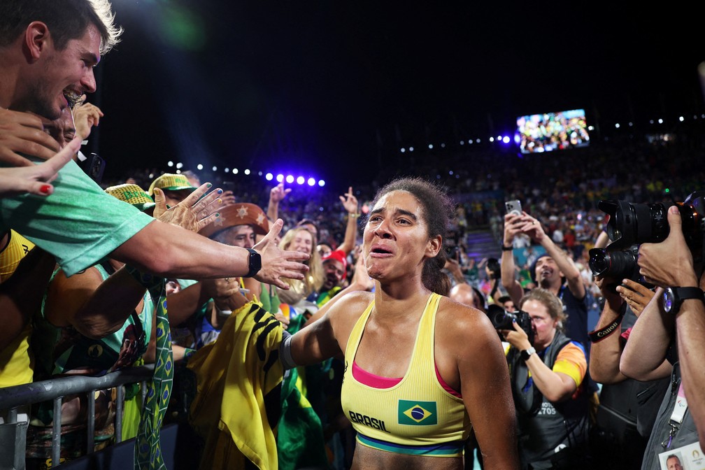 Ana Patrícia cumprimenta o público emocionada após conquistar a medalha de ouro no vôlei de praia com Duda sobre as canadenses Melissa e Brandie — Foto: Louisa Gouliamaki/Reuters