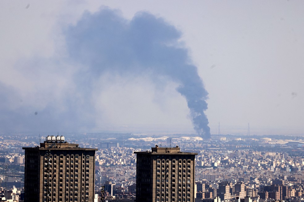 Fumaça é vista em refinaria de petróleo após um ataque israelense na capital iraniana, Teerã, em 17 de junho de 2025. — Foto: Photo by Atta Kenare/AFP