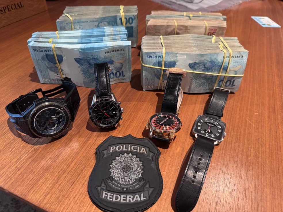 Dinheiro e relógios de luxo apreendidos durante operação sobre fraude no INSS. — Foto: Polícia Federal