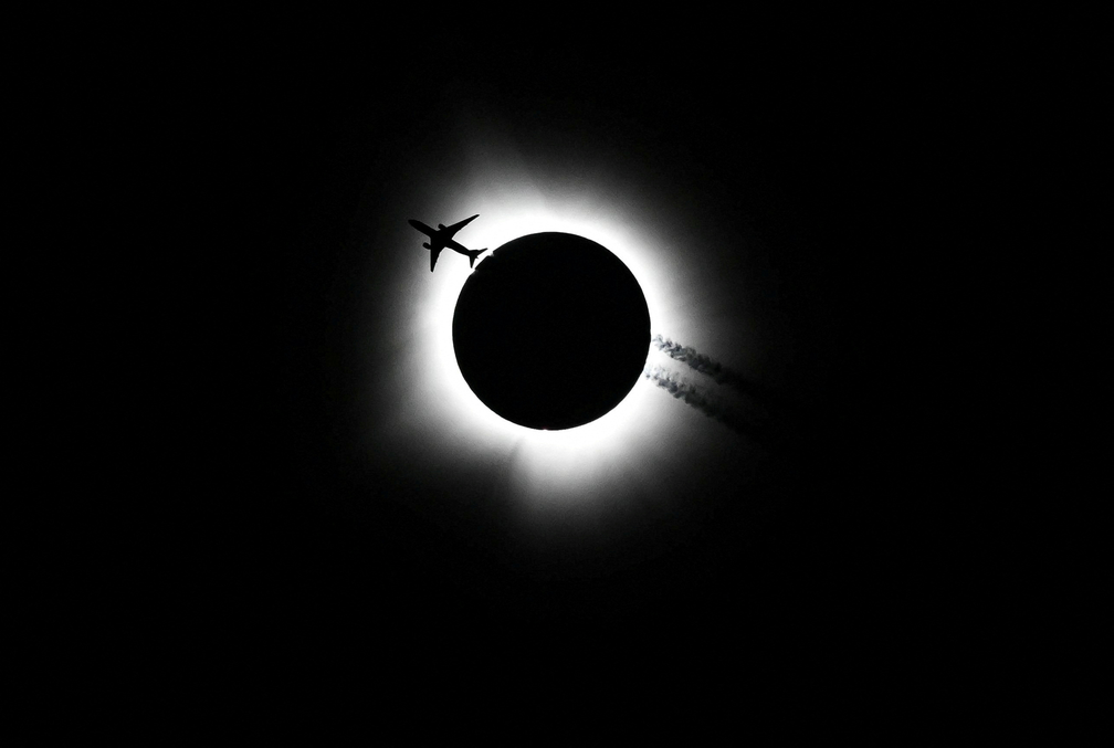 Um avião passa perto do eclipse solar total durante em Bloomington, Indiana, nos EUA, nesta segunda-feira (8). — Foto: Bobby Goddin/USA Today via Reuters