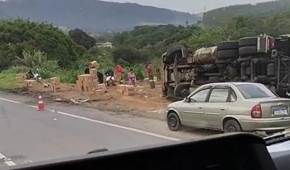 Caminhão tomba fora da pista e carga de biscoito é saqueada na Fernão Dias, em Itapeva, MG — Foto: Reprodução / Redes sociais