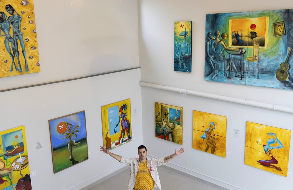 O artista plástico Lui Risco e as telas da exposição 'Olhar de Girassol' — Foto: Divulgação