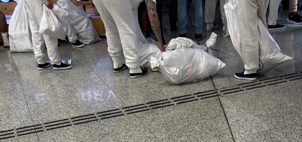 Brasileiros deportados dos EUA chegam em Confins com pertences em um saco — Foto: Rafaela Mansur/ g1